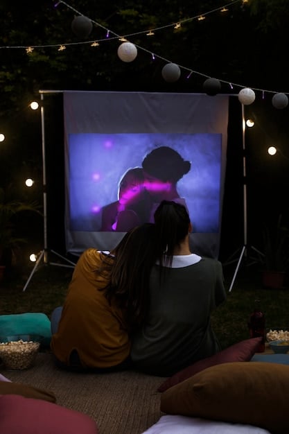 A close-up shot of a high-quality outdoor projector displaying a crisp, clear image on a white screen in a darkened backyard setting.