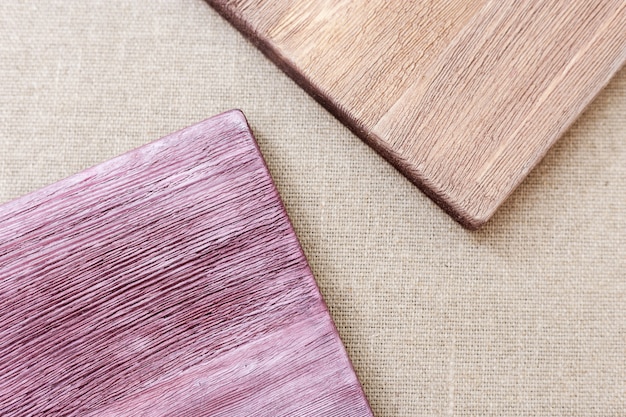 A close-up shot of various wood samples, including pine, oak, and plywood, displaying different grain patterns and textures. The samples are arranged on a workbench with measuring tools nearby, emphasizing the importance of material selection in woodworking projects.