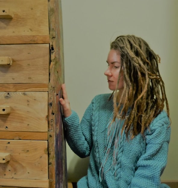 A person assembling a wooden bookshelf using wood glue, screws, and clamps. The focus is on the precision and care required to align and secure the joints, ensuring a sturdy and well-constructed piece of furniture.