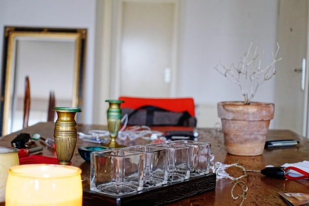Detailed shot of a well-stocked DIY home bar. Focus is on the organized arrangement of liquor bottles, glassware, and bar tools on the shelves. The lighting is warm, highlighting the labels and colors of the different spirits, creating an inviting and sophisticated atmosphere.