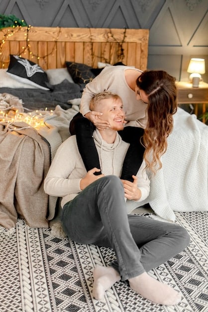 A parent comforting a child in a cozy living room setting. The parent is kneeling to be at the child's eye level, offering a supportive embrace. The background is soft and blurred, emphasizing the emotional connection between the parent and child.
