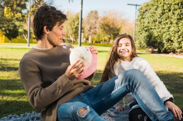 A young girl receiving a piggy bank from her father, both smiling, suggesting early lessons in saving money. Outdoors, well lit and positive.