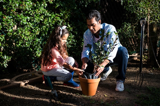 A single father is volunteering in a community garden, teaching a group of children how to plant vegetables. The scene conveys a sense of community engagement and contribution.