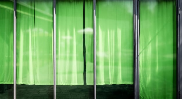 A close-up of a neatly stretched white blackout fabric screen on a PVC pipe frame in a green backyard, ready for a movie night, illustrating a cost-effective DIY screen solution.